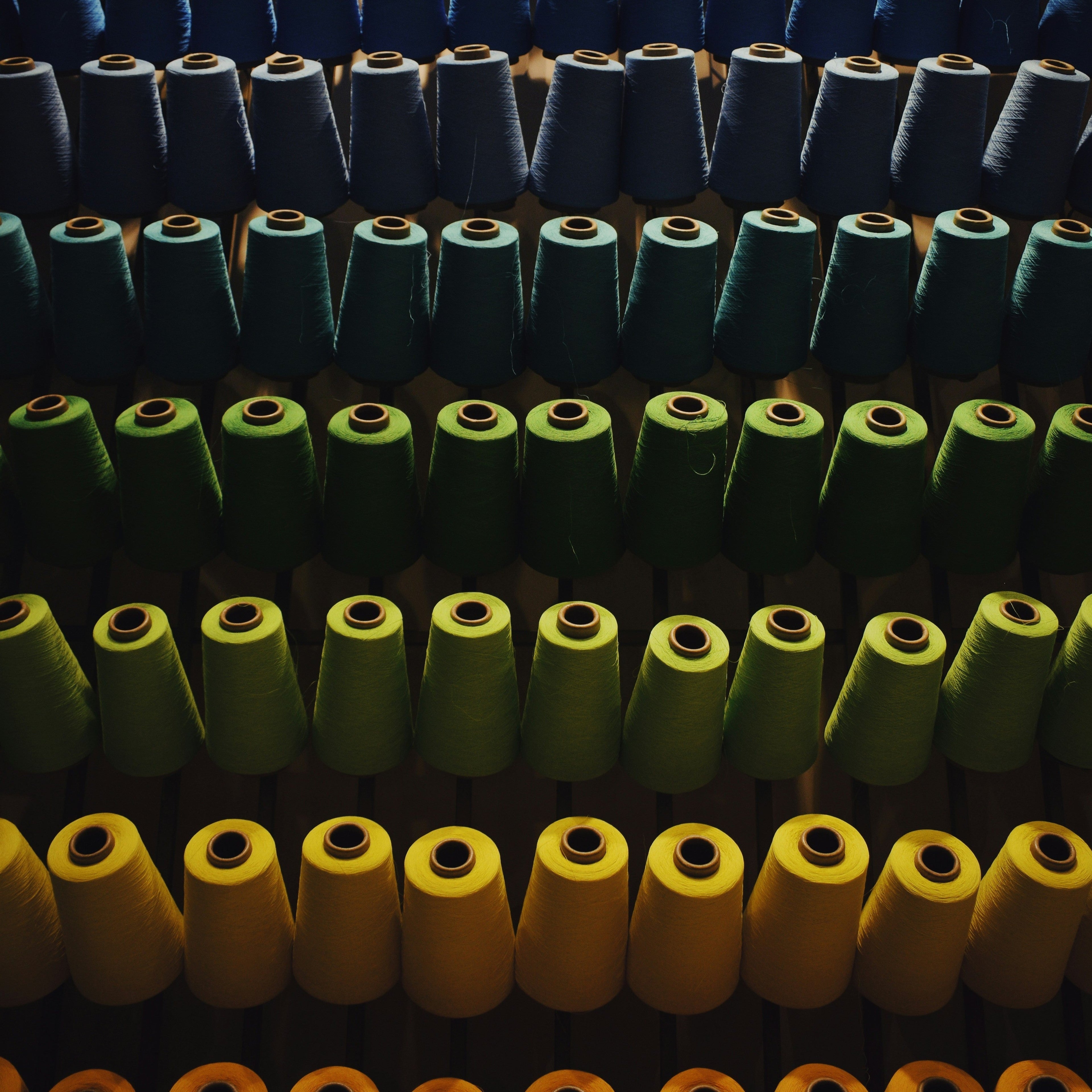 Colorful cones of yarn on a vertical rack.