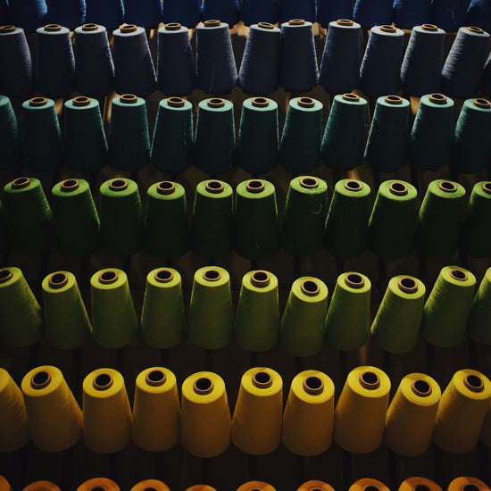 Colorful cones of yarn on a vertical rack.